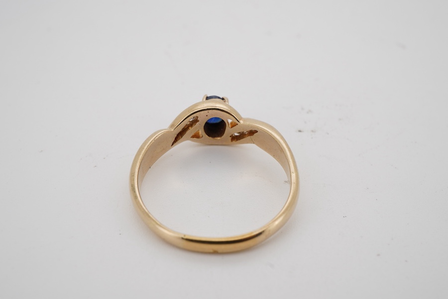 A modern 18k yellow metal and single stone oval cut sapphire set ring, with six stone diamond chip set shoulders, size U/V. gross weight 6 grams.